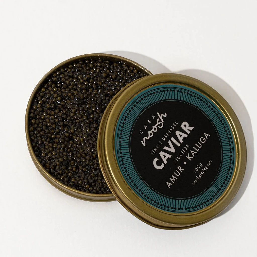 Caviar in an open gold container with a black label on a white background